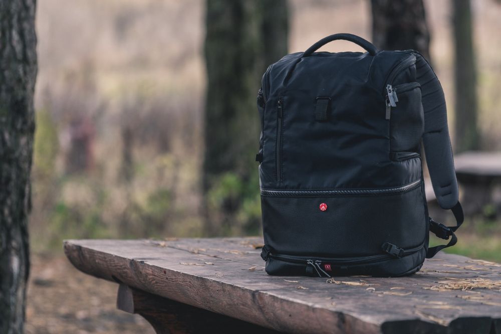 navy blue backpack on a wooden table in the woods