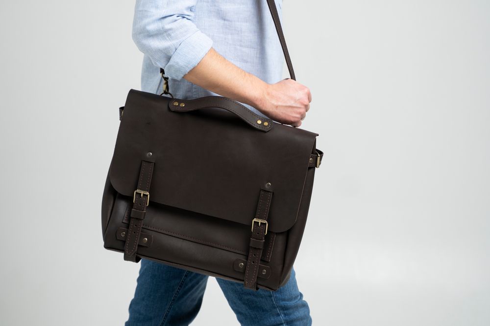 man carrying a brown leather messenger bag