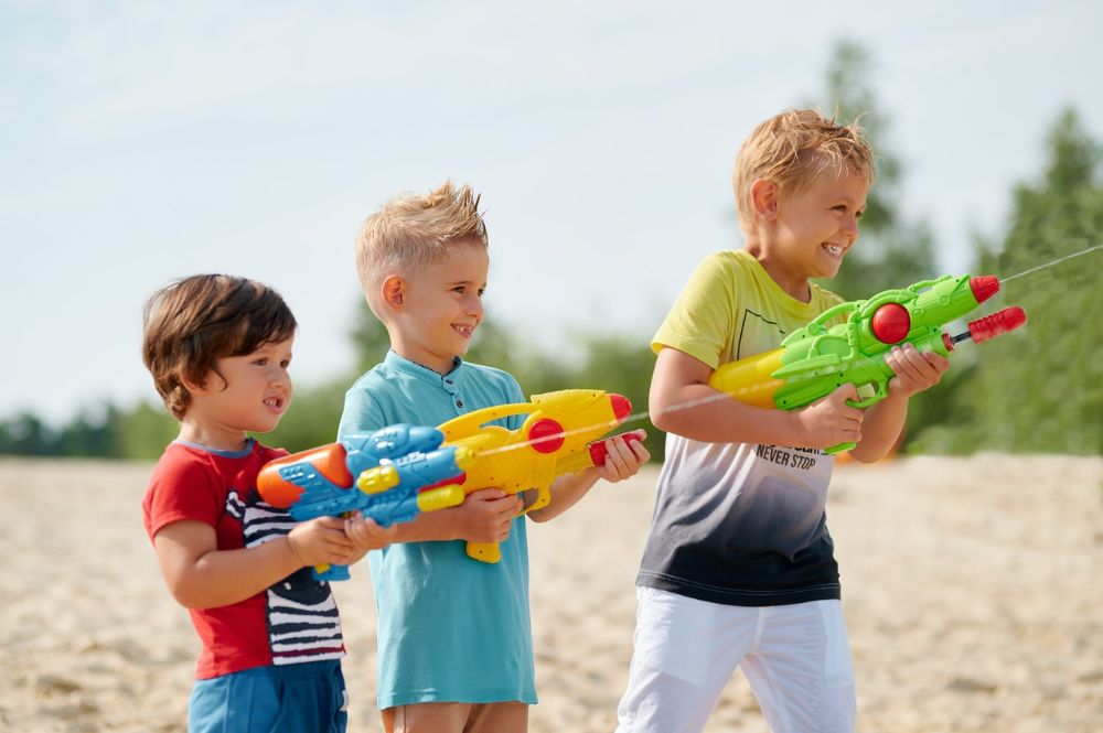 three kids shooting water from water gun