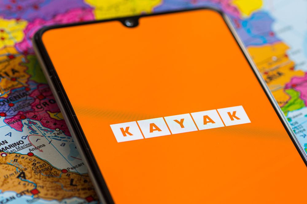 Kayak logo shown on phone with the world map as the background